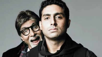 Amitabh Bachchan intently listens to his son Abhishek in a studio setting.